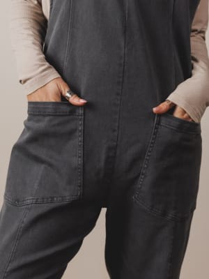Person wearing dark gray pants with a neutral background