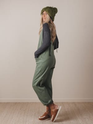 Person wearing a green outfit with a beanie against a plain background