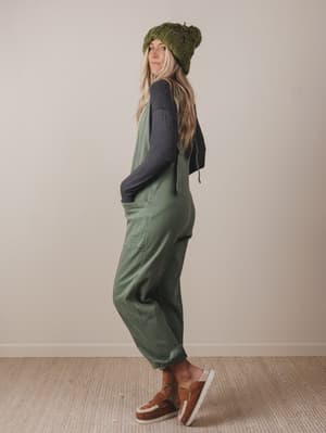 Person wearing a green outfit with a beanie against a plain background