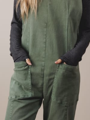 Person wearing a green jumpsuit with a plain background