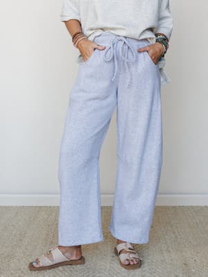 Wide-leg heather gray sweatpants styled with a matching gray sweatshirt, stacked boho bracelets, and buckle sandals — the kind of outfit that makes staying home feel like a whole personality.