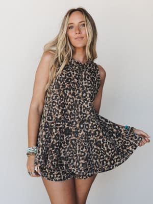A breezy leopard print matching set — flowy sleeveless top and shorts — styled with stacked boho bracelets and a relaxed, effortless feel against a soft neutral studio backdrop.