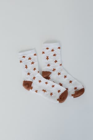 A pair of Super Star Socks - White, featuring white fabric with brown toes, heels, cuffs, and a chic brown star pattern, are laid flat on a plain light background.