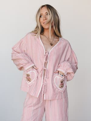 A relaxed matching set in red and cream gingham gets a playful, nostalgic twist with heart-shaped pockets and embroidered teddy bear patches — the kind of outfit that feels like a Saturday morning with nowhere to be.