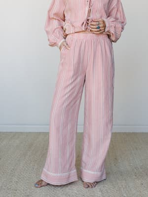 A relaxed matching set in a soft pink and cream striped check, styled together with a cropped tie-front top and wide-leg pants — the kind of outfit that blurs the line between staying in and going out, in the best way.