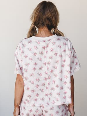 A back-view shot of a floral waffle-knit tee with matching shorts, styled with pearl hair clips — soft, lived-in, and the kind of set you'd actually wear all morning.
