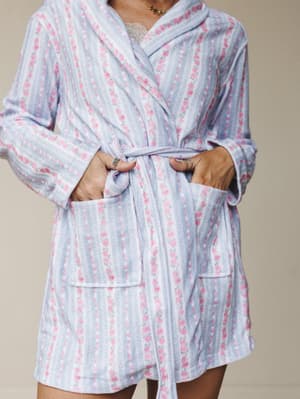 A cozy floral robe in soft periwinkle blue with pink rose stripe print, styled open over a lace cami — the kind of thing you wear while pretending you'll get dressed eventually.