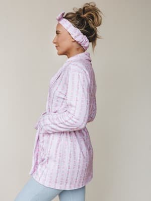 A soft floral-striped robe in lavender pink is styled with matching knotted headband and pale blue ribbed leggings — the kind of morning look that makes staying in feel completely intentional.
