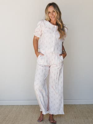 A matching floral stripe pajama set in soft cream and pink — the kind of set that blurs the line between sleepwear and something you'd actually wear to a Saturday morning farmers market.