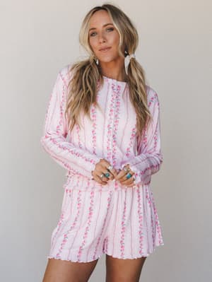 A soft, dreamy matching set in blush pink with vertical floral stripe print — the kind of outfit that blurs the line between cozy-at-home and genuinely cute out-in-the-world, styled with turquoise and silver rings for a sweet boho finish.
