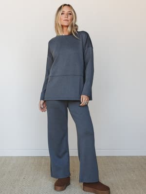 A matching charcoal set — relaxed long-sleeve top and wide-leg pants in a soft heathered knit — styled with stacked silver rings and platform UGG boots for that effortlessly cozy, pulled-together look.