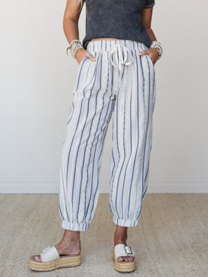 Relaxed striped jogger pants in cream and navy styled with a washed cropped tee, platform espadrille sandals, and stacked bracelets — the kind of outfit that looks effortless but was definitely thought about.
