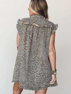 Shot from the back, a flowy leopard-print mini dress with ruffle trim detailing and flutter sleeves — styled with stacked boho bracelets that hint at the kind of person who wears this on a good day just because.