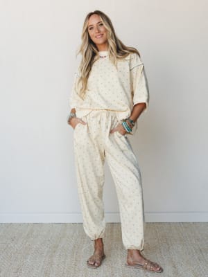 A matching polka dot two-piece set in soft butter yellow styled with stacked turquoise bracelets and flat sandals — the kind of outfit that looks pulled-together without trying too hard.