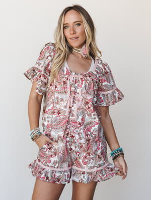 A paisley-print matching set — flowy top and ruffle-hem shorts — styled with stacked bracelets and a tassel choker for that effortless boho-summer feel.