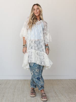 A cream lace duster layered over a soft blue top and floral-print denim joggers — the kind of outfit that looks effortless but definitely took thought, styled with platform espadrille sandals and a stack of boho bracelets.