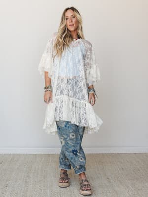 A cream lace duster layered over a soft blue top and floral-print denim joggers — the kind of outfit that looks effortless but definitely took thought, styled with platform espadrille sandals and a stack of boho bracelets.