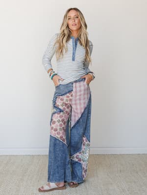 A wide-leg patchwork denim jean styled with a grey striped henley long-sleeve — the kind of outfit that looks like it was thrown together effortlessly but absolutely wasn't.