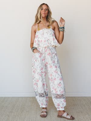 A flowy ivory floral two-piece set styled with a mustard bralette, stacked beaded bracelets, and sandals — effortlessly boho and made for warm-weather days that stretch into evenings.
