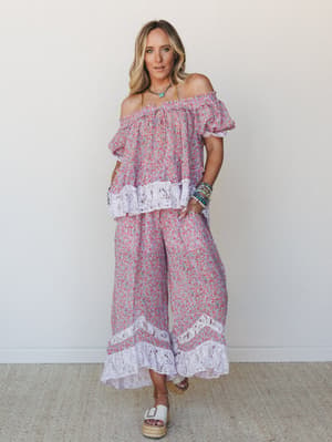 A matching floral two-piece set in soft lavender and red ditsy print, styled with stacked turquoise bracelets and platform espadrilles — the kind of outfit that makes a farmers market run feel like a mini vacation.