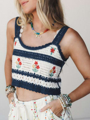 A cropped crochet tank in navy and cream stripes with hand-embroidered floral details, styled with flowy embroidered pants and layered boho jewelry — the kind of outfit that looks like a good summer day.