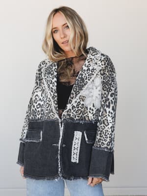 A mixed-media blazer with a leopard print knit upper and washed black denim lower half, styled over a black lace top with light wash jeans — the kind of jacket that does all the talking for you.