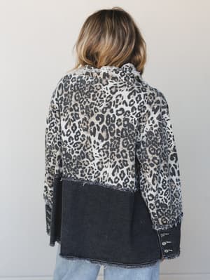 Shot from the back, this mixed-media blazer pairs a leopard print top half with a washed black denim lower half, finished with raw frayed edges throughout — the kind of piece that does all the talking for you.