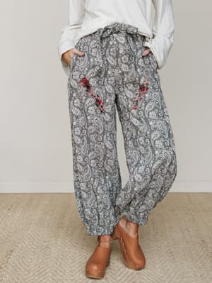 A relaxed, lived-in paisley pant with plaid pocket contrast and a paperbag waist, styled with an oversized white top and tan clogs for that effortless, cozy-cool everyday look.