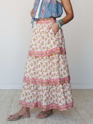 A tiered floral maxi skirt in cream with pink and yellow rose print, styled with an embroidered chambray top and strappy sandals — the kind of outfit that feels like a farmers market morning turned into something worth remembering.