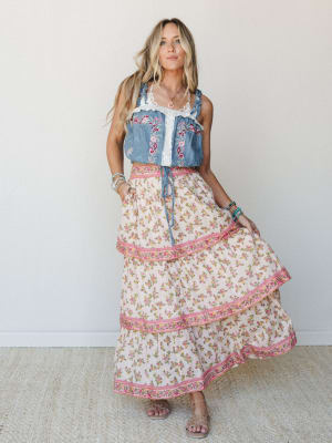 A flowy tiered maxi skirt in a ditsy floral print pairs with an embroidered denim crop top — the kind of outfit that looks like it was effortlessly pulled together but absolutely wasn't.