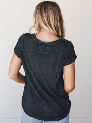 A back-view shot of a worn-in black burnout tee with that perfectly broken-in feel — the kind of top that becomes your default without you even noticing.