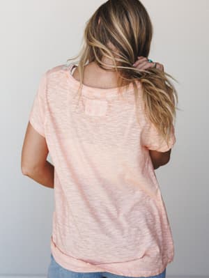 A back-view shot of a relaxed peach burnout tee with a lived-in texture, styled casually with denim — the kind of top that looks like it's been your favorite for years.