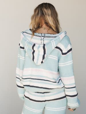 A back-view shot of a cozy striped knit hoodie in soft sky blue, layered over matching wide-leg pants — the kind of set that makes staying in feel like a whole mood.