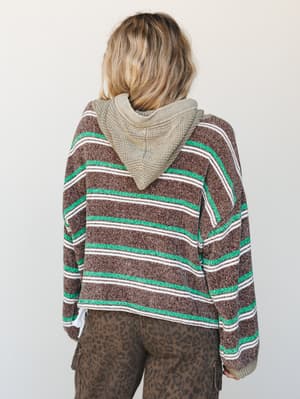 Shot from the back, this chunky striped hoodie in chocolate brown, kelly green, and cream is styled with leopard print cargo pants — relaxed, a little retro, and very much the kind of outfit you wear on purpose.