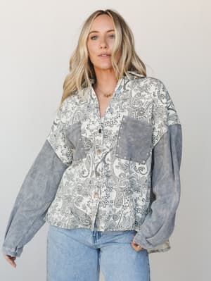 A relaxed mixed-fabric jacket in cream and grey paisley paired with light wash jeans — the kind of piece that does the heavy lifting between 'just running errands' and 'actually put together.'
