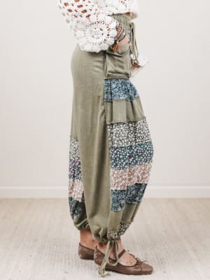 Person wearing a pair of patchwork pants with a plain background