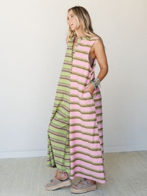 A breezy striped maxi jumpsuit in pink and olive green worn with espadrille platform sandals and a stack of turquoise bracelets — the kind of outfit that looks just as good on a cobblestone street as it does at a backyard lunch.