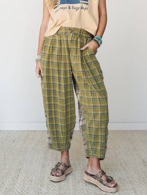 Relaxed plaid wide-leg pants in a faded olive and sage mix, styled with a graphic tee, stacked beaded bracelets, and platform espadrille sandals — the kind of outfit that looks effortless but was absolutely thought about.