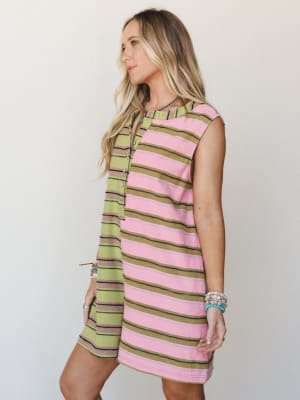 A breezy striped romper in pink, olive, and mocha worn with stacked beaded bracelets — the kind of easy one-and-done piece that looks like you tried without trying.