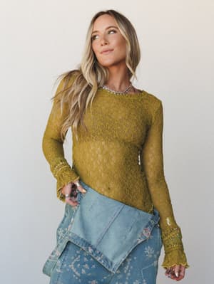 A sheer olive-gold lace long sleeve top styled with floral-embroidered jeans and a silver choker — the kind of layered, textured look that feels effortlessly put-together without trying too hard.
