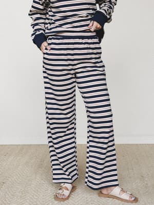 A matching stripe set in navy, cream, and red — wide-leg sweat pants with an elastic waist paired with a coordinating striped pullover, styled with cream buckle sandals for that effortlessly relaxed, thrown-together-but-not look.