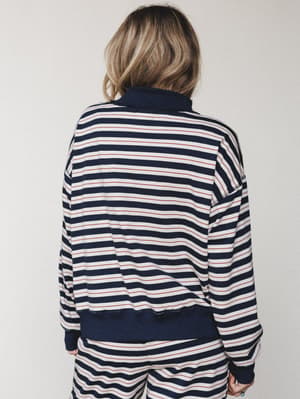 A back-view shot of a matching navy striped sweatshirt and wide-leg pants set — the kind of cozy, put-together look that makes staying in feel intentional.