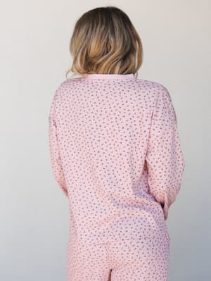 A back-view shot of a matching floral print set in soft pink — the ribbed texture and ditsy floral pattern give it that cozy, lived-in quality that feels equally at home on a slow Sunday morning or a casual coffee run.
