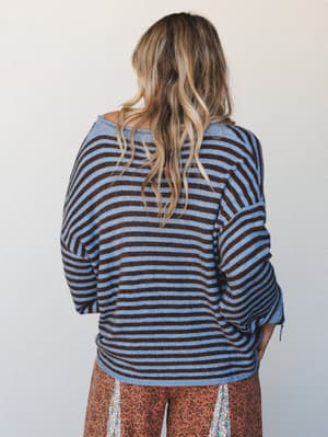 Shot from the back, a relaxed striped knit top pairs with floral wide-leg pants — the kind of effortless mix-and-match that looks accidental but totally isn't.