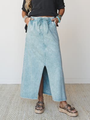 A mineral-washed maxi skirt in a soft ash blue pairs with a dark textured crop top and espadrille platform sandals — the kind of effortless outfit that looks like you tried just enough.