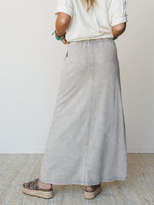A mineral-washed maxi skirt in a soft slate gray pairs effortlessly with a cream waffle knit tee and espadrille platform sandals — the kind of outfit that looks like it took five minutes and zero effort, in the best way.