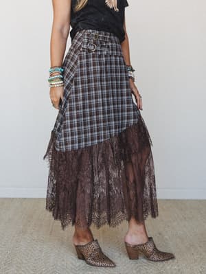 A plaid midi skirt with a dramatic lace hem makes a strong case for mixing textures — styled with a graphic tee, stacked beaded bracelets, and leopard mules for a look that's equal parts boho and a little bit rock and roll.