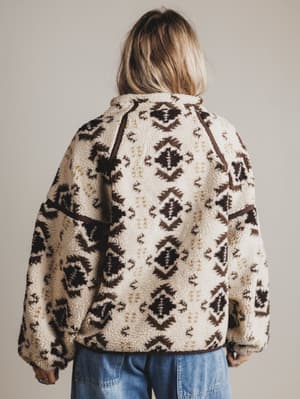 Person wearing a patterned fleece jacket with a neutral background