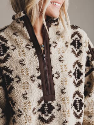 Person wearing a patterned fleece jacket with a zipper