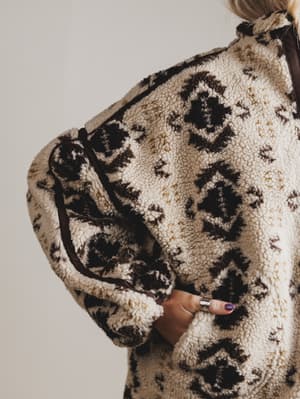 Close-up of a person wearing a patterned coat with a neutral background